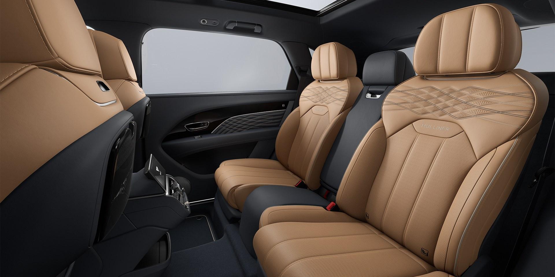 The rear cabin of a Bentley Bentayga Mulliner in tan and black leather with diamond quilting