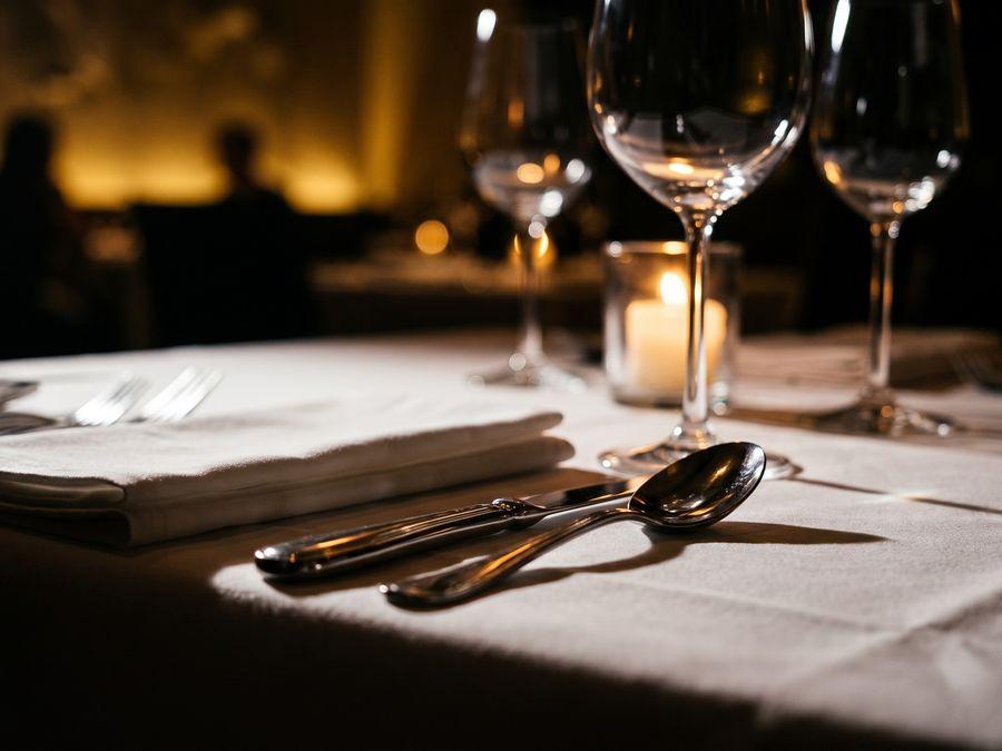 A linen-and-silver table setting in candlelight