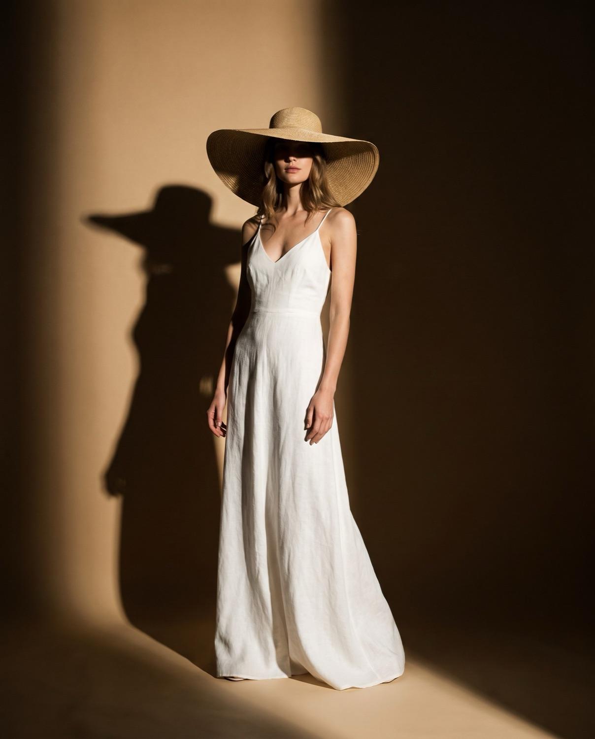 A flowing white linen evening dress with a wide-brim hat