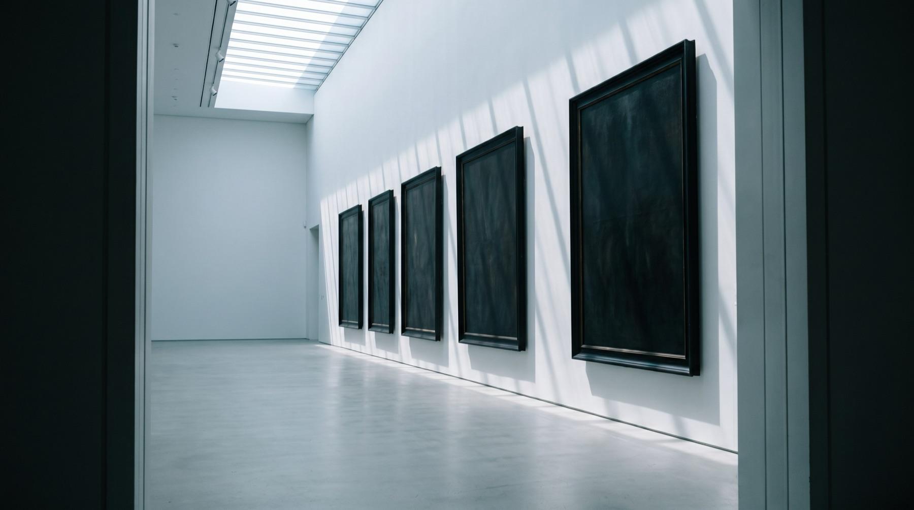 A quiet gallery room with large canvases in even light
