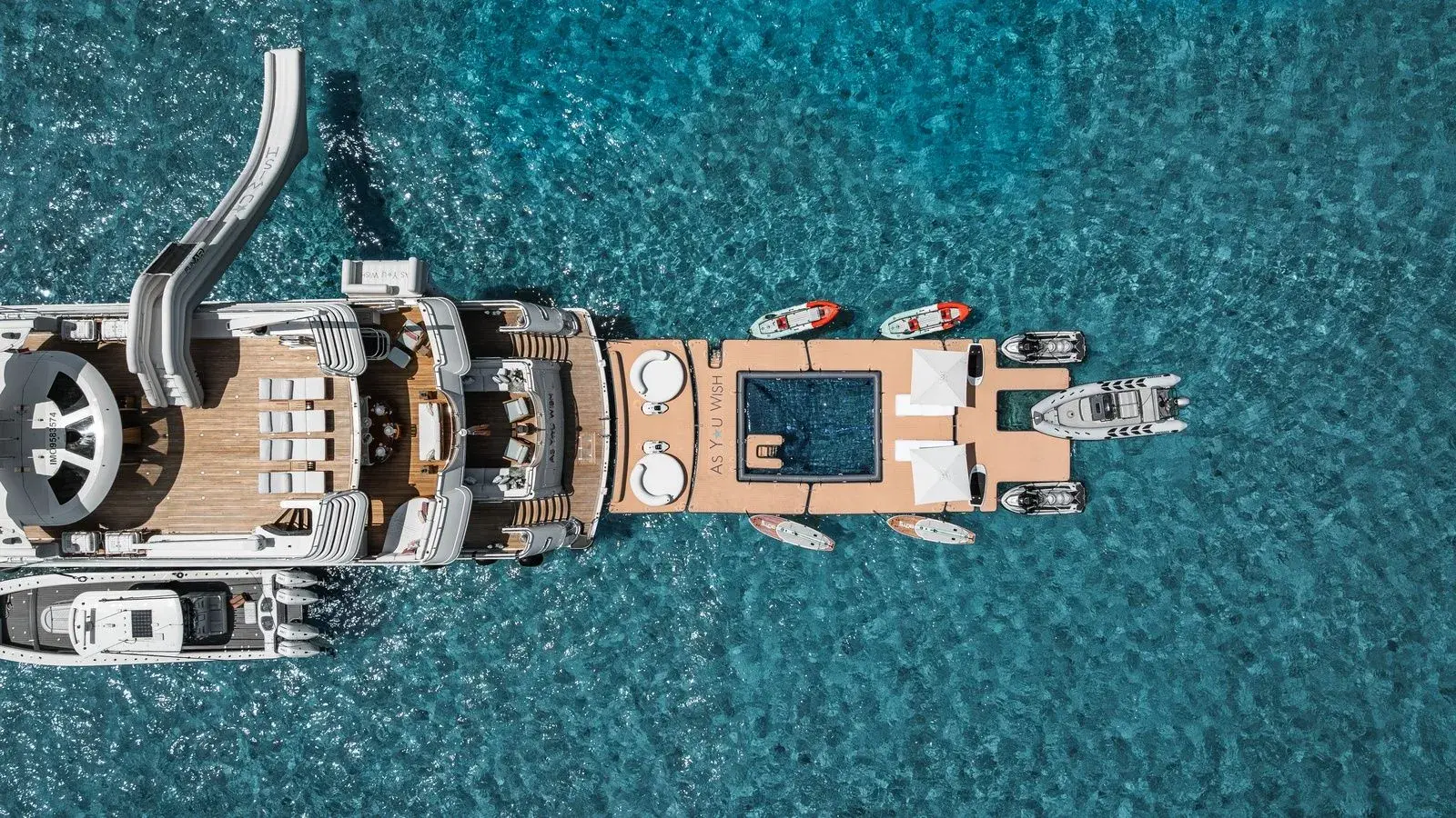 AS YOU WISH from above at anchor: the tender, the jet skis and the sea pool laid out around her