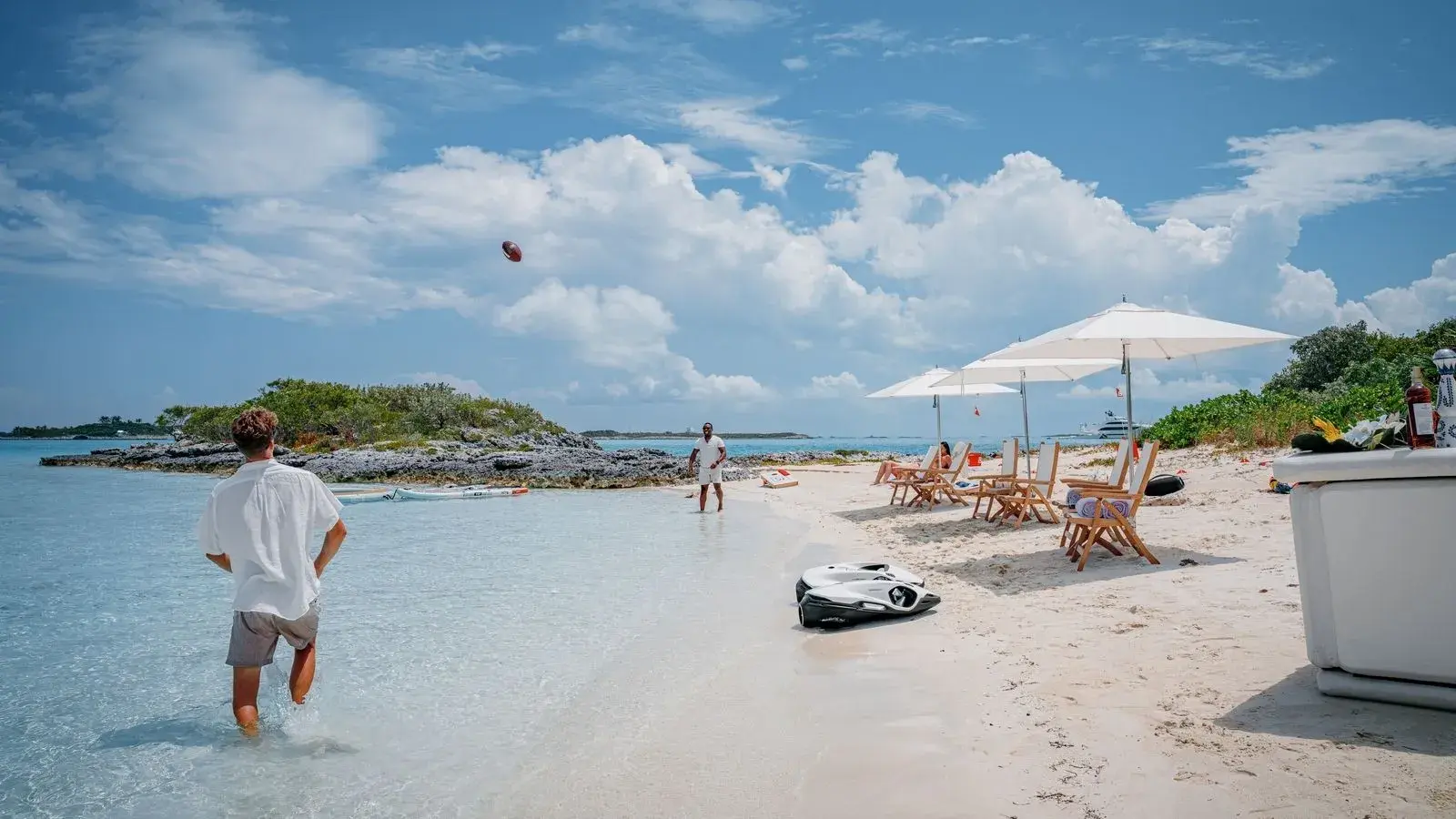 The beach setup: umbrellas and chairs on the sand, the tender waiting